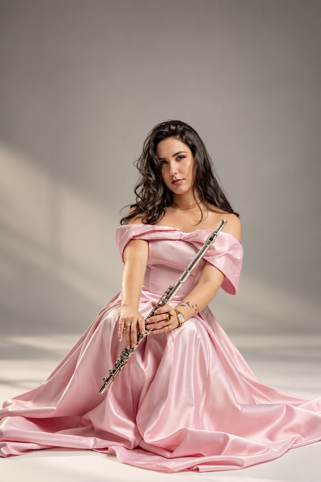 Legna Otero seated in a pink gown with her flute