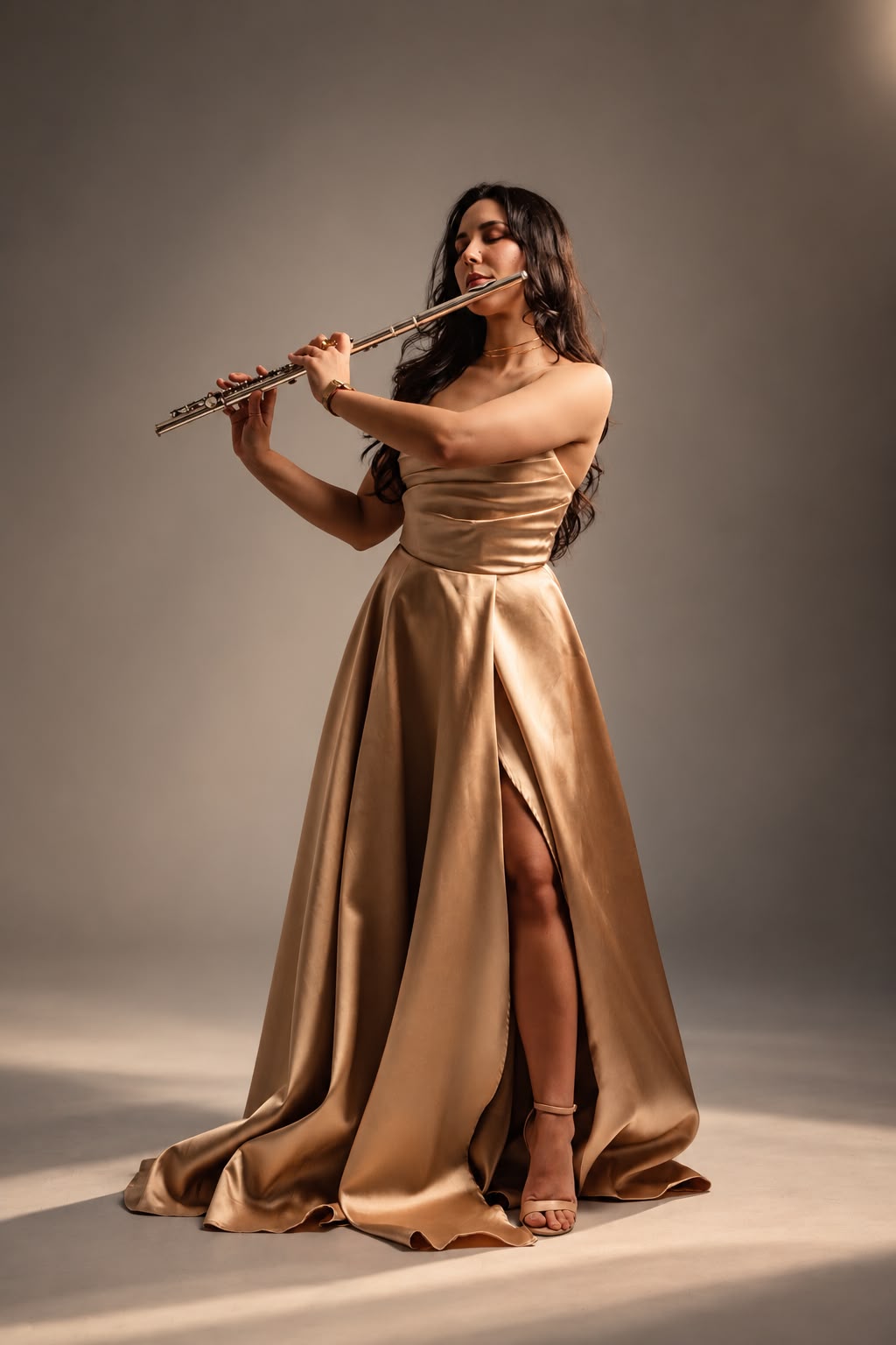 Legna Otero playing the flute in a gold gown