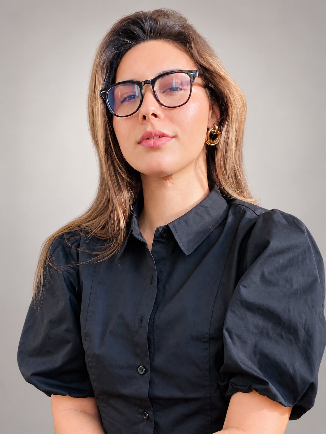 Portrait of Legna Otero, music teacher, wearing glasses and a black shirt